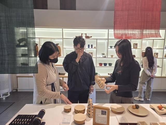 15일 전주공예품전시관을 찾은 관광객들이 전북도 무형유산 민속목조각장인 김종연 장인이 민화 속 '까치호랑이'를 현대적으로 재현한 목조조각을 보고 있다. 육경근 기자