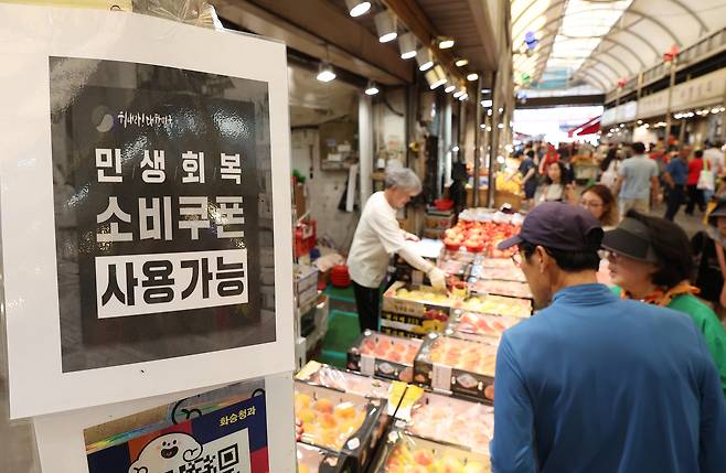 A signboard outside a market in Dongdaemun District in eastern Seoul that reads government consumer coupons can be used. [YONHAP]