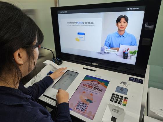 An AI assistant serves a customer at Shinhan Bank’s AI-powered branch in central Seoul. [SHINHAN BANK]