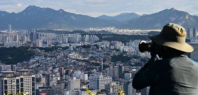 서울 전역 및 경기 12개 지역을 규제지역 지정하고 LTV 40%로 축소하는 10.15 부동산 대책이 발표된 가운데 15일 오전 서울 남산에서 한 시민이 서울 시내 아파트를 바라보고 있다. 이상섭 기자