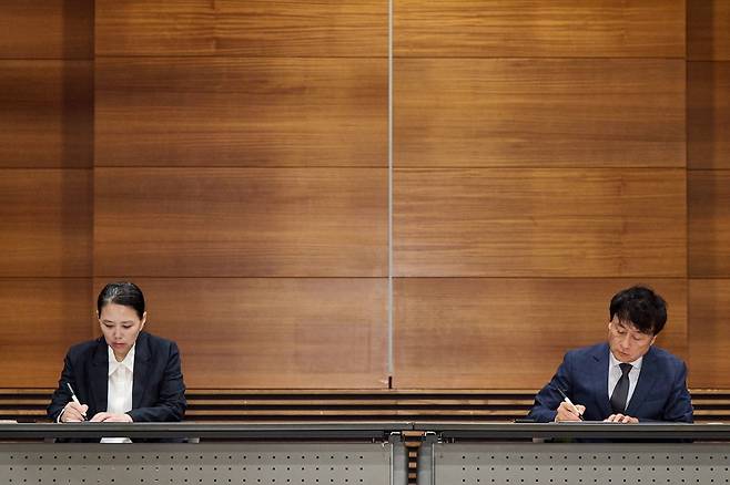 합의문에 사인하는 장연미 씨와 안형준 사장