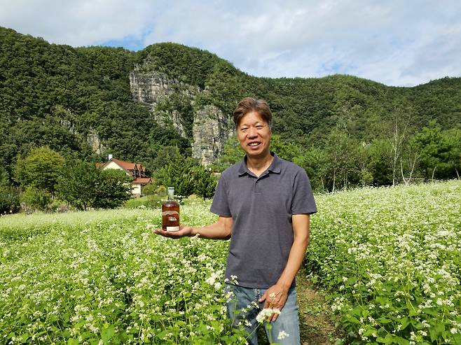 메밀밭에서 포즈를 취한 박성호 맹개마을 대표 겸 농업회사법인 밀과노닐다&nbsp;기획이사. 최현태 기자