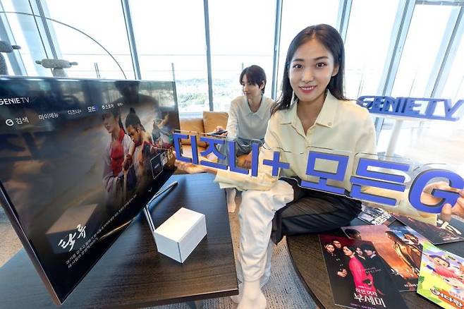 모델들이 ‘모든G 전용 메뉴’ 화면 앞에서 ‘지니 TV 디즈니+ 모든G’를 소개하고 있다. 사진=KT