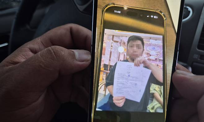 보파씨가 15일 취재진에게 최근 웬치에서 탈출한 한국인이 중국인에게 돈을 빌린다는 차용증을 들고 있는 사진을 보여주고 있다.