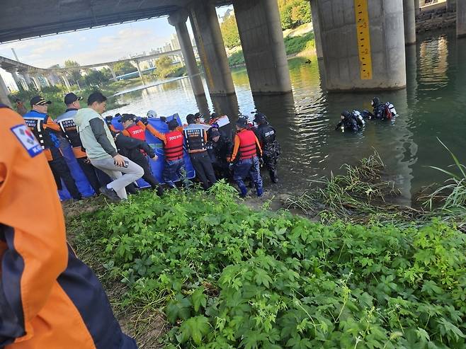 ▲ 소방당국이 중랑천 동막교 인근 하천에서 실종자로 추정되는 시신을 발견해 수습하고 있다. /사진제공=북부소방재난본부