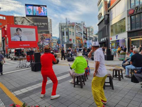 광복로 거리 공연에 어르신들이 백댄서가 되어 춤을 추며 즐기고 있다.