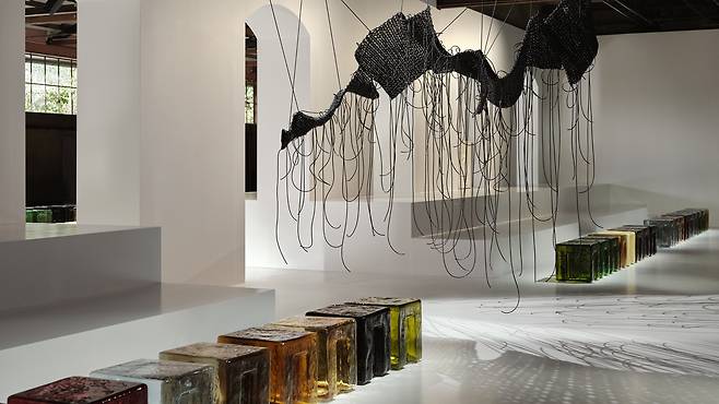 보테가 베네타 2026 여름 쇼 현장 내부는 디자인 브랜드 6:AM과 협업한 맞춤형 무라노 유리 스툴 시리즈가 좌석으로 마련됐고, 천장 곳곳에는 현대 미술가 이광호의 작품이 배치돼 있었다. /보테가 베네타