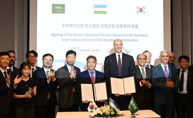 이학재(왼쪽) 인천국제공항공사 사장과 오마르 알 미다니 비전인베스트 대표가 14일(현지시간) 우즈베키스탄 타슈켄트 인터컨티넨탈 호텔에서 '타슈켄트 국제공항 운영 컨설팅 계약서'를 나란히 들고 참석자들과 기념 촬영을 하고 있다. 타슈켄트=최주연 기자