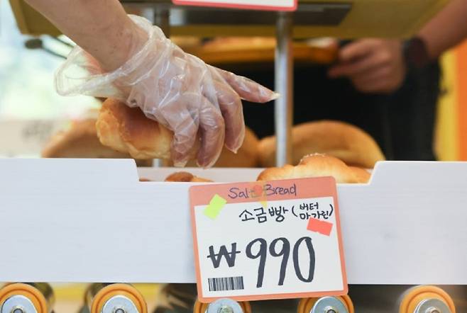 지난 8월 서울 성동구에서 열린 유튜버 ‘슈카월드’의 베이커리 팝업 스토어 ETF베이커리를 찾은 시민들이 990원에 판매되는 소금빵을 고르고 있다. 뉴시스