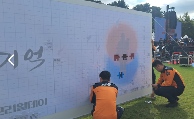 ▲ 소방관들이 '메시지월'에 순직 소방관들에게 전하는 메시지를 부착하고 있다.