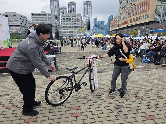 이날 고급 자전거 경품에 당첨된 시민이 기뻐하고 있다.