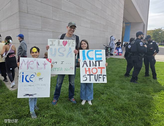 “나는 미국 사랑하는데…내가 안티파?” 18일(현지시간) 미국 워싱턴에서 열린 ‘노 킹스’ 시위에 어린 자녀와 함께 참여한 시민이 ‘나는 미국을 사랑하는데, 그러면 나도 안티파?’라고 쓰인 손팻말을 들고 있다. 정유진 특파원