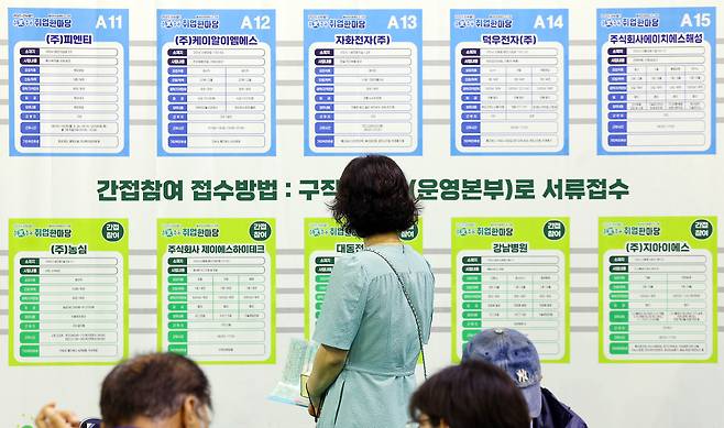 Job seekers review company recruitment information during a job fair in Gumi, North Gyeongsang on July 16. [YONHAP]