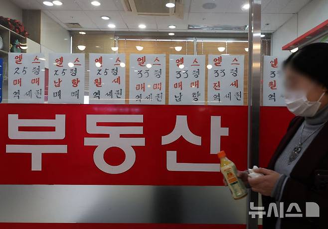 [서울=뉴시스] 배훈식 기자 = 정부의 '10·15 부동산 대책' 첫날인 16일 오후 서울 송파구의 한 공인중개사 사무소 앞을 시민이 지나가고 있다.  정부는 지난 15일 수도권·규제지역의 주택담보대출 한도를 주택 가격에 따라 기존 6억원에서 2억원까지 축소하는 내용의 '주택시장 안정화 대책'을 발표했다. 2025.10.16. dahora83@newsis.com