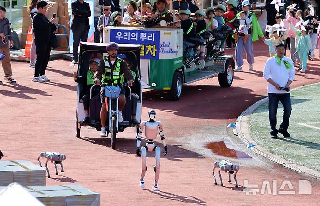 [서울=뉴시스] 이영환 기자 = 19일 오전 서울 용산구 효창운동장에서 열린 제43회 대통령기 이북도민 체육대회에서 평안북도 선수단과 휴머노이드로봇, 로봇개가 입장을 하고 있다. 2025.10.19. 20hwan@newsis.com