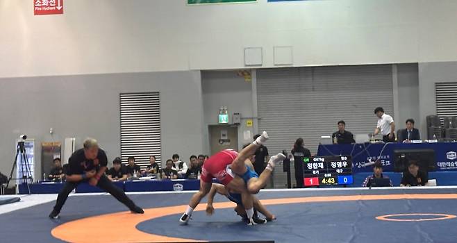 20일 부산광역시 벡스코 제2전시장에서 열린 제106회 전국체육대회 레슬링 남자일반부 그레코로만형 67㎏급 결승에서 정한재(수원특례시청·빨간색 유니폼)가 대구 대표 정영우(상무)를 상대로 안아던지기를 시도하고 있다. <이세용 기자>