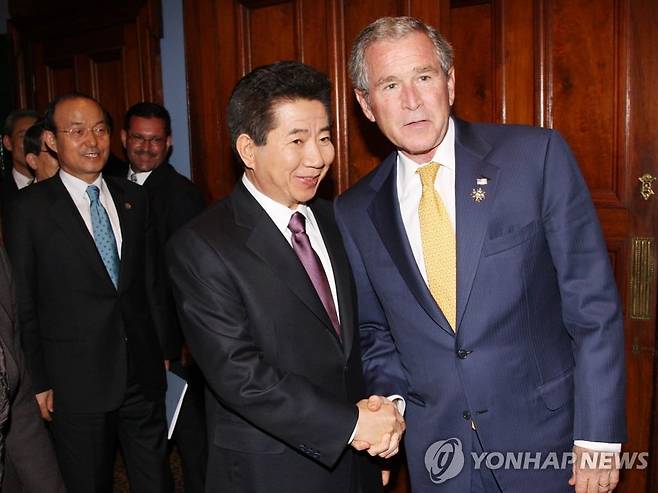 2007년 9월 7일 아태경제공동체(APEC) 정상회의 참석차 호주를 방문중인 노무현 대통령과 조지 부시 미국 대통령이 시드니 인터콘티넨탈호텔에서 정상회담을 하기에 앞서 악수하고 있다. '빙하는 움직인다'의 저자 송민순 당시 외교부 장관이 두 정상의 뒤에서 미소 짓고 있다. /연합뉴스