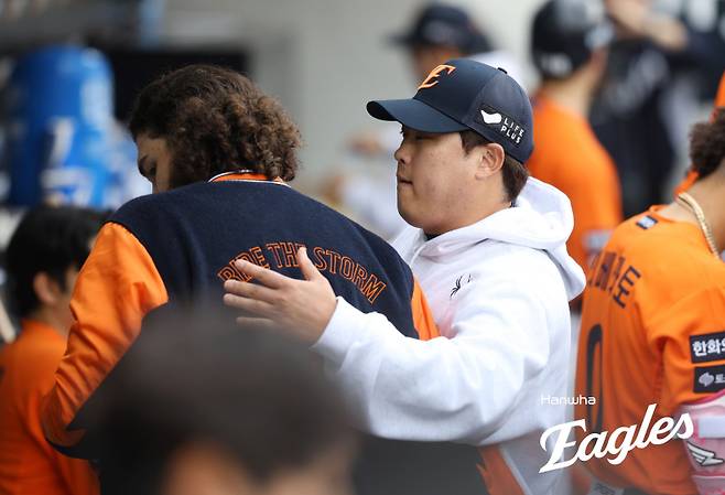 류현진이 18일 플레이오프 1차전에서 선발 투수 임무를 마친 폰세를 격려하고 있다. 사진=한화 이글스