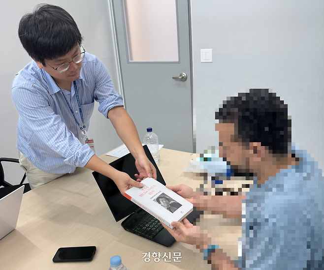 난민인권네트워크 관계자가 지난 8월28일 인천국제공항 출국대기실 접견실에서 이집트 출신 인권변호사 A씨(오른쪽)에게 고 조영래 변호사가 남긴 글을 엮은 책 <진실을 영원히 감옥에 가두어둘 수는 없습니다>를 전달하고 있다. 난민인권네트워크 제공