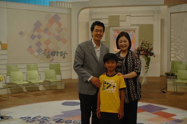 김재원 아나운서가 10여년 전 캄보디아 소년을 집으로 데려와 한 달을 보냈을 당시 모습. 아침마당을 함께 진행한 이금희 아나운서와 기념촬영을 하는 장면. 김 아나운서 제공