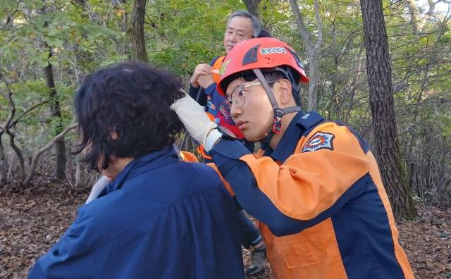 20일 오후 1시 59분 통영시 사량도 지리산을 등산 중이던 70대 여성이 5m 높이 바위에서 추락해 머리를 다쳤다. 신고를 받고 출동한 산악구조봉사대와 소방정대가 응급처치 후 부상자를 업고 하산하고 있다. 통영소방서 제공