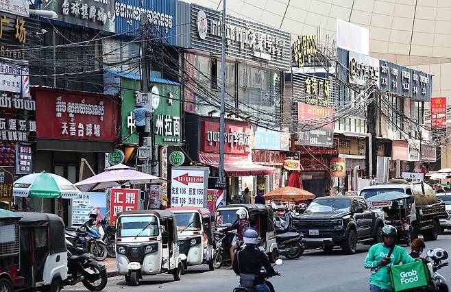 19일(현지시간) 캄보디아 프놈펜 한 거리 상가에 중국어와 크메르어가 혼재된 간판들이 붙어 있다. 2025.10.19.뉴스1