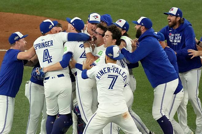 토론토 선수들이 21일 미국프로야구 메이저리그 아메리칸리그 챔피언결정 7차전에서 시애틀을 4-3으로 꺾고 월드시리즈 진출을 확정 지은 뒤 기뻐하고 있다. 토론토=AP 뉴시스