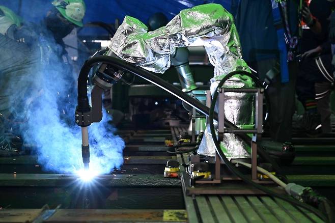 HD현대미포가 지난 20일 건조 중인 선박 위에서 실시한 '협동로봇 및 최신 자동용접 기법 시연회'에서 협동로봇이 덱(Deck) 블록을 용접하고 있다. HD현대미포 제공