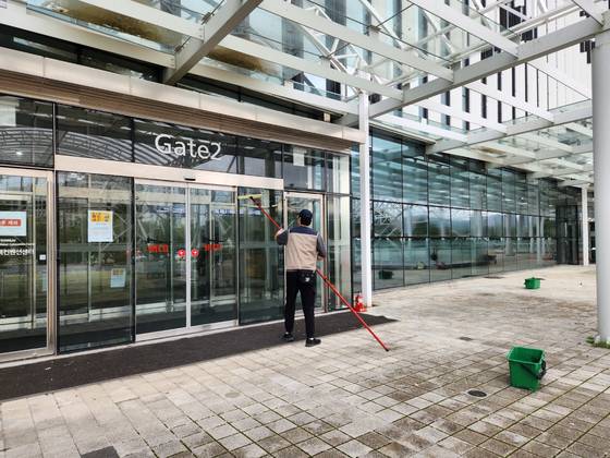 A worker cleans an entrance door to the Gyeongju Hwabaek International Convention Center in the Bomun Tourist Complex in Gyeongju, North Gyeongsang, on Oct. 20. [KIM JUNG-SEOK]