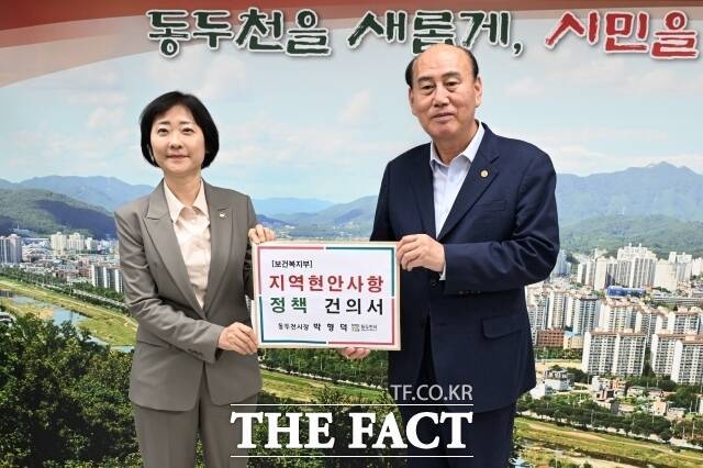 박형덕 경기 동두천시장(오른쪽)이 지난 21일 동두천시청사를 방문한 이스란 보건복지부 차관에게 지역 보건의료체계 개선 내용이 담긴 건의서를 전달하고 있다. /동두천시