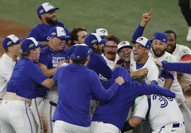 <yonhap photo-2811="">토론토 선수단이 지난 21일(한국시간) ALCS 7차전에서 시애틀을 꺾고 32년 만에 월드시리즈 진출을 확정짓자 기뻐하고 있다. UPI=연합뉴스</yonhap>