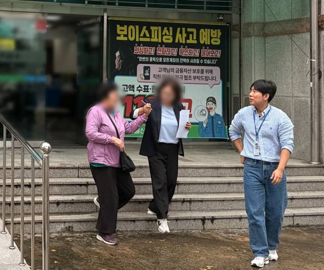 지난 16일 오후 울산 북구 중울산농협 상방지점에서 보이스피싱에 넘어가 1억 원을 출금하려던 70대 여성을 경찰과 은행원이 막고 있다. 사진제공=울산경찰청