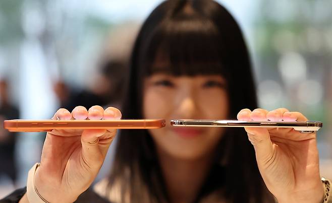 19일 오전 서울 중구 명동 애플스토어에서 한 시민이 이날 출시된 애플의 스마트폰 '아이폰 에어'(오른쪽)와 '아이폰17프로'의 두께를 비교하고 있다. /뉴스1