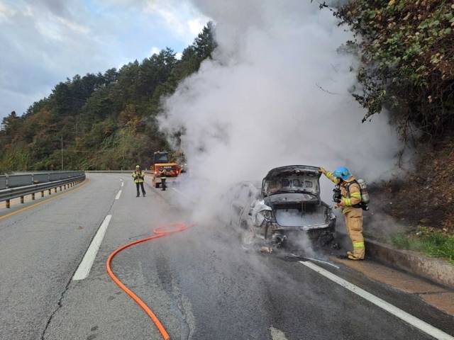 ▲ 23일 7시 8분쯤 춘천시 신동면 덕만이터널 인근에서 승용차가 굴착기를 들이받으며 불에 탔다. 강원소방본부 제공