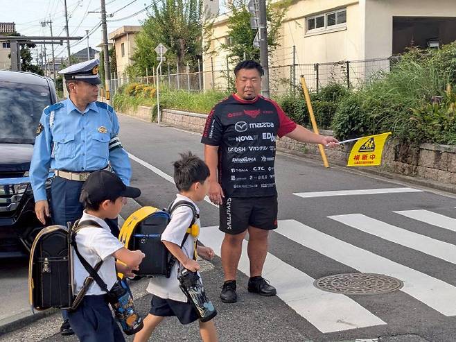 일본 초등학교 앞 도로에서 럭비 선수들이 봉사활동을 하고 있다(사진=마쓰다 스카이액티브스 구단)