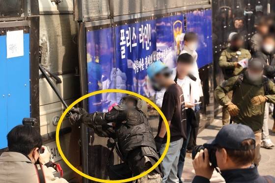 지난 4월 4일 서울 종로구 헌법재판소 인근에서 윤석열 당시 대통령 지지 집회 참가자 중 한 명이 헌재의 윤 대통령 파면 결정에 경찰이 세운 가벽 사이로 보이는 차량을 부수고 있는 모습. 〈사진=연합뉴스〉