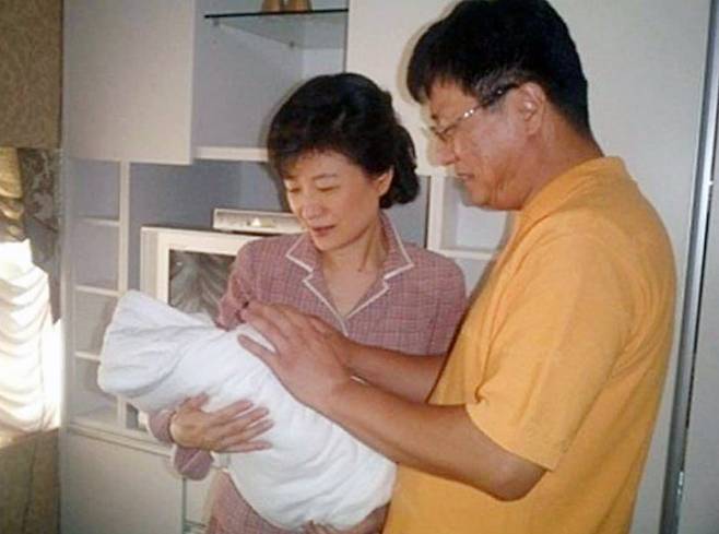 지난 2005년 9월 박정희 전대통령의 손자인 세현 군이 태어났을 당시 조카를 품에 안은 박근혜 대통령과 남동생 박지만 회장./ 온라인커뮤니티