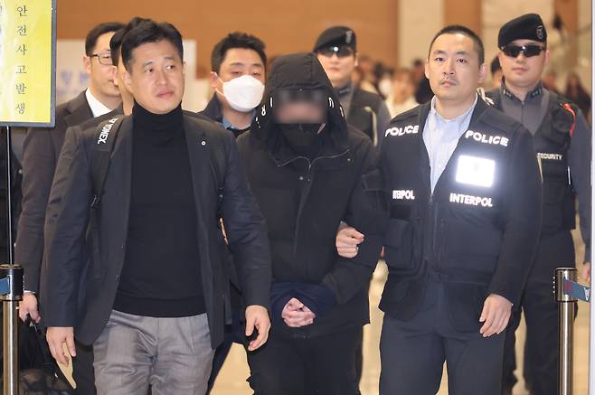 The 26 year-old, who is accused of masterminding a blackmail scheme using drinks mixed with drugs, entering the Incheon International Airport on Dec. 26, 2023, after being extradited from China. The person only identified as Lee has been in China since October 2022 while he was on trial for another extortion case. [YONHAP]