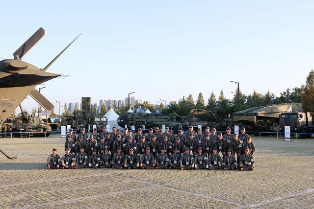 서울 아덱스 2025 폐막을 앞둔 24일 이른 아침, 일산 킨텍스 야외전시장에 파견된 육군 각 부대의 장병들이 한자리에 모여 서로의 노고를 치하하고 있다. 사진 왼쪽에 수리온 헬리콥터 꼬리날개 부분이 보인다. 사진 뒤에는 K9A1 자주포와 KM2 자주도하차량, 장애물개척전차, 가교전차 등에 관람객들의 관심이 집중됐다. 킨텍스(고양)=서울 아덱스 2025 공동운영본부 제공