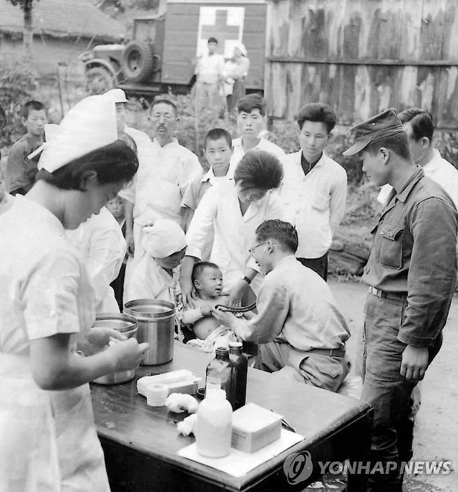 수해지구 주민에게 무료진료활동을 벌이고 있는 군의관 1963년 수해지구 주민에게 무료진료활동을 벌이고 있는 군의관. 1963.7.10[연합뉴스 자료사진]