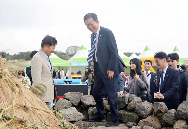 정청래 더불어민주당 대표가 25일 제주시 애월읍 새별오름 에서 열린 제주 도새기 축제장에서 제주 전통 옛 화장실인 '돗통시'를 살펴보고 있다 / 연합뉴스