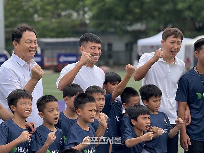 베트남 축구대표팀 김상식(오른쪽부터) 감독, 부이 티엔중, 이운재 코치가 어린이들과 기념 사진을 찍고 있다. 하노이 | 정다워 기자