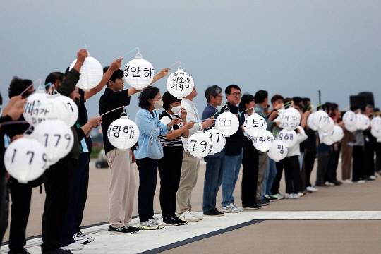 추석인 6일 오후 전남 무안군 무안국제공항 활주로에서 열린 12·29 제주항공 여객기 참사 유가족 협의회의 추모행사에서 유가족들이 유등을 들고 오열하고 있다. 연합뉴스