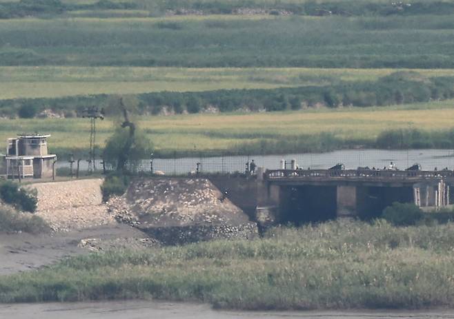 북한의 정권수립일(9.9절)을 하루 앞둔 8일 인천 강화군 강화평화전망대에서 바라본 북한 황해북도 개풍군의 한 마을 인근 다리에서 북한군이 경계근무를 서고 있다. 2025.09.08. 뉴시스