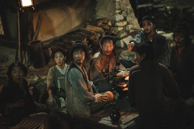 드라마 '탁류'에서 숨겨왔던 과거의 비밀을 들켜 노역꾼에서 왈패가 된 시율이 무덕과 아내, 왈패 부하들과 같이 밥을 먹다 손가락으로 무언가를 가리키고 있다. 디즈니플러스 제공