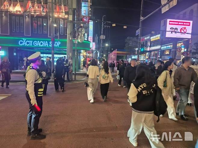 [서울=뉴시스] 이윤석 수습기자=핼러윈을 앞둔 25일 오후 서울 마포구 홍대입구역 인근. 경찰이 횡단보도 앞에서 시민들의 이동을 통제하고 있다. 2025.10.25. leeys@newsis.com