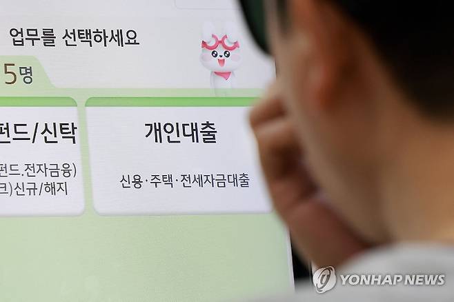 (서울=연합뉴스) 신현우 기자 = 정부가 부동산시장 안정 대책을 발표한 15일 서울 시내 시중은행을 찾은 시민이 상담 받기 위해 번호표를 뽑고 있다. 2025.10.15 nowwego@yna.co.kr 연합뉴스