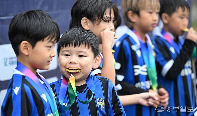 &nbsp;제7회 중부일보사장배 유소년 축구대회에서 한 선수들이 메달을 깨물고 있다.정선식기자