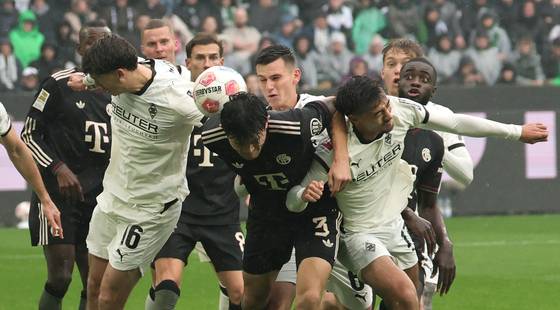 Philipp Sander of Moenchengladbach, left, in action against Kim Min-jae of Munich, center, during the German Bundesliga soccer match between Borussia Moenchengladbach and FC Bayern Munich in Moenchengladbach, Germany on Oct. 25 [EPA/YONHAP]