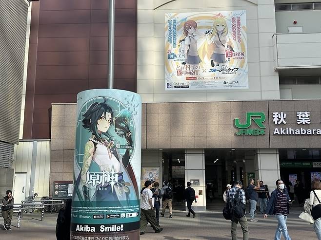 2023년 하반기 일본 아키하바라역 광장 앞에 가판대와 벽면 광고판에 중국 호요버스 게임 ‘원신(왼쪽)’과 넥슨게임즈 ‘블루아카이브’ 광고가 배치돼 있다. [매경DB]